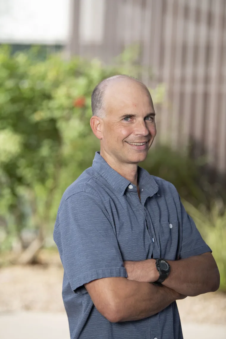 Professional portait of a white man in a grey polo